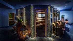 Ein Spa-Raum mit einer Mosaikwand, Holzsitzen und einem Massagesessel.
