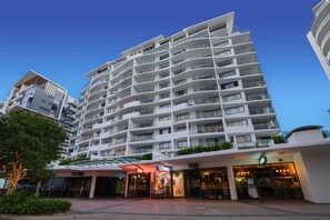 A multi-story hotel with balconies, a ground-level entrance, and a visible bar area.