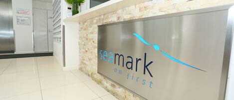 A reception desk with a sign that reads "seamark on first" and a decorative vase with flowers.