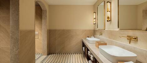 A modern bathroom with a large bathtub, two sinks, and a mirror.