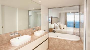 A modern bathroom with two sinks, a bathtub, and a large mirror.