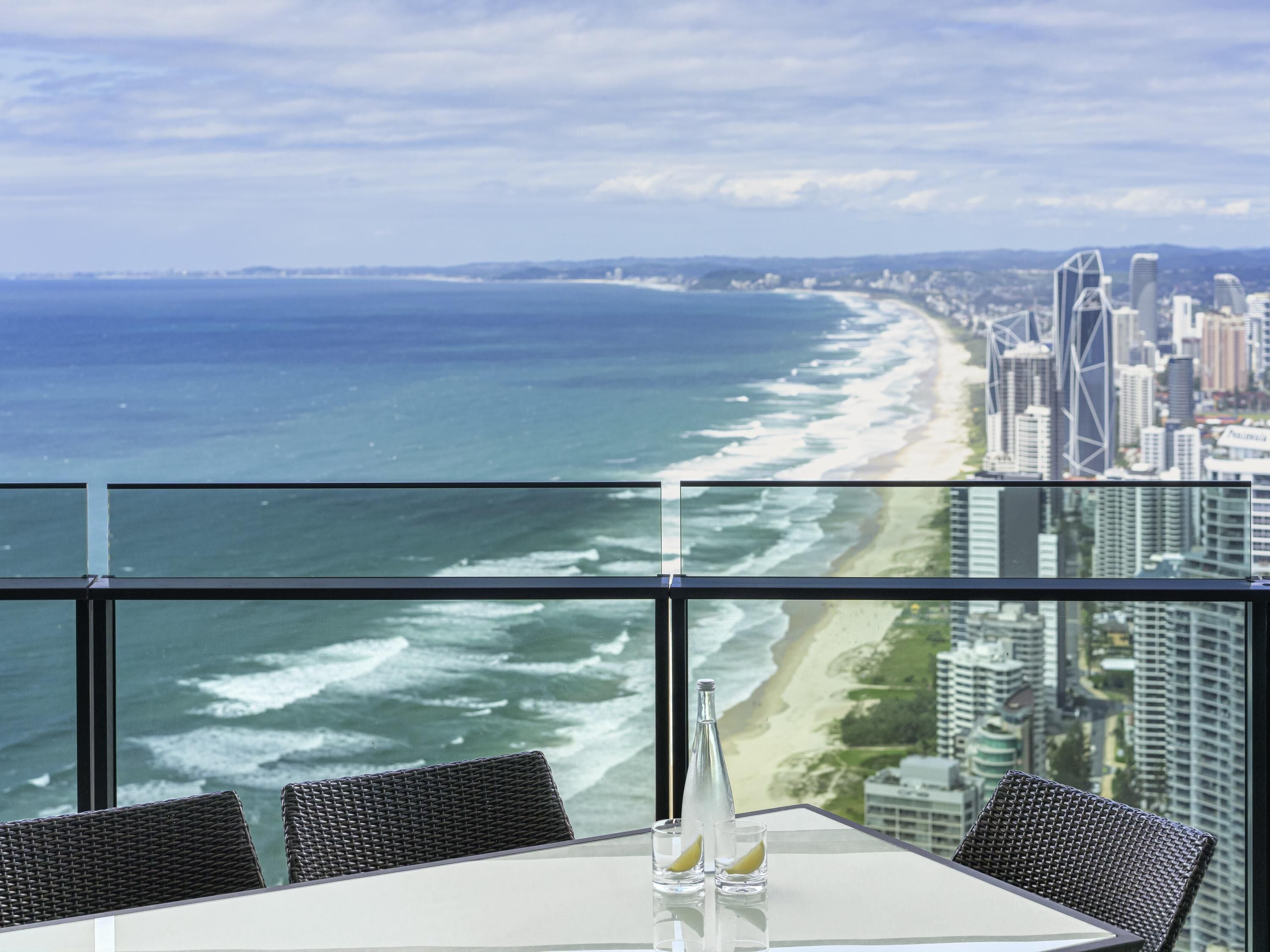 A high-rise room with a view of the beach and city skyline.