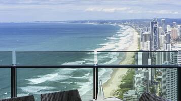 A high-rise room with a view of the beach and city skyline.