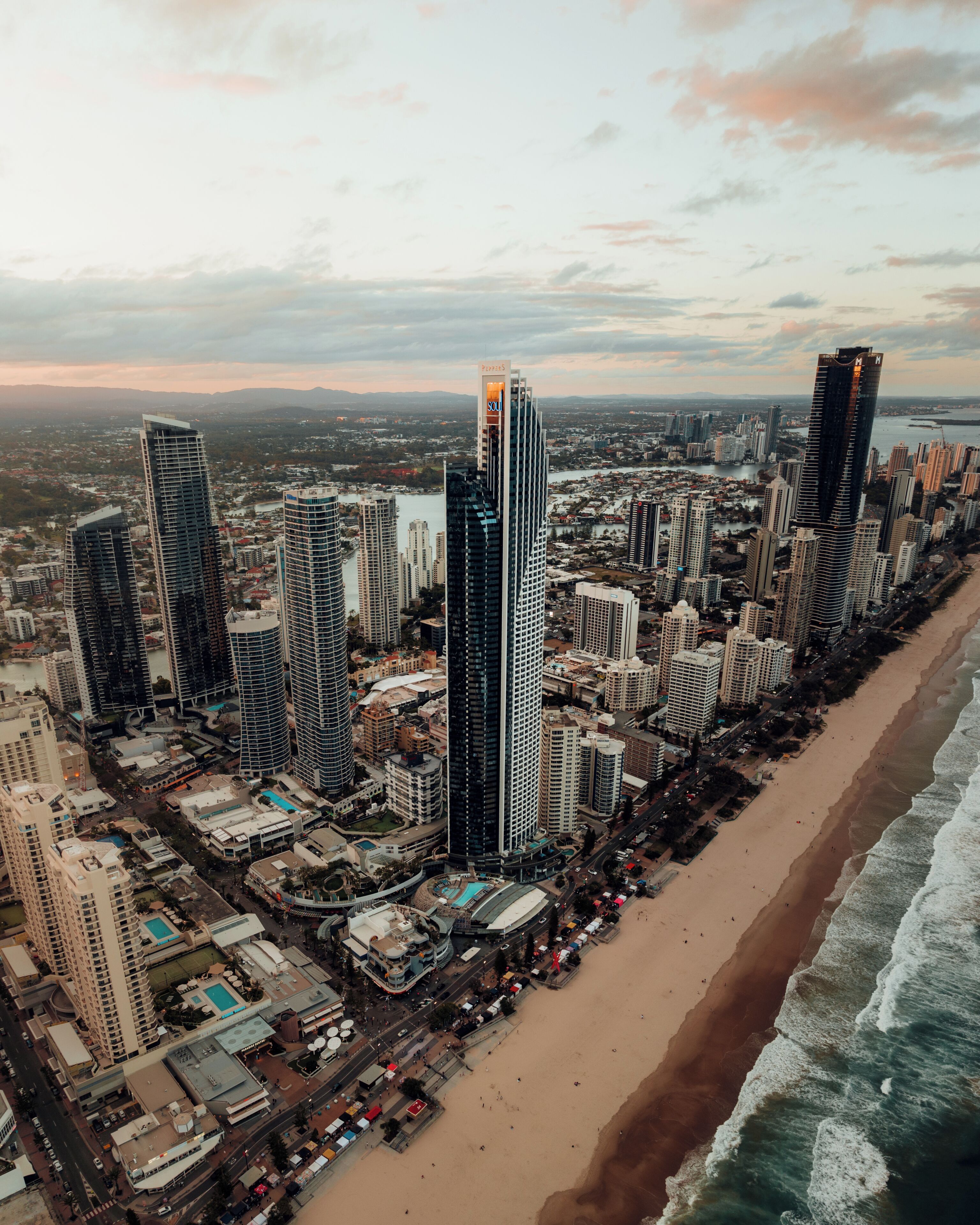Un paisaje urbano costero con rascacielos, una playa y un río.