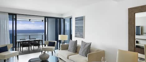 A modern hotel room with a balcony, a dining area, and a living space.