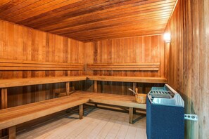 A sauna with wooden benches and a towel rack.