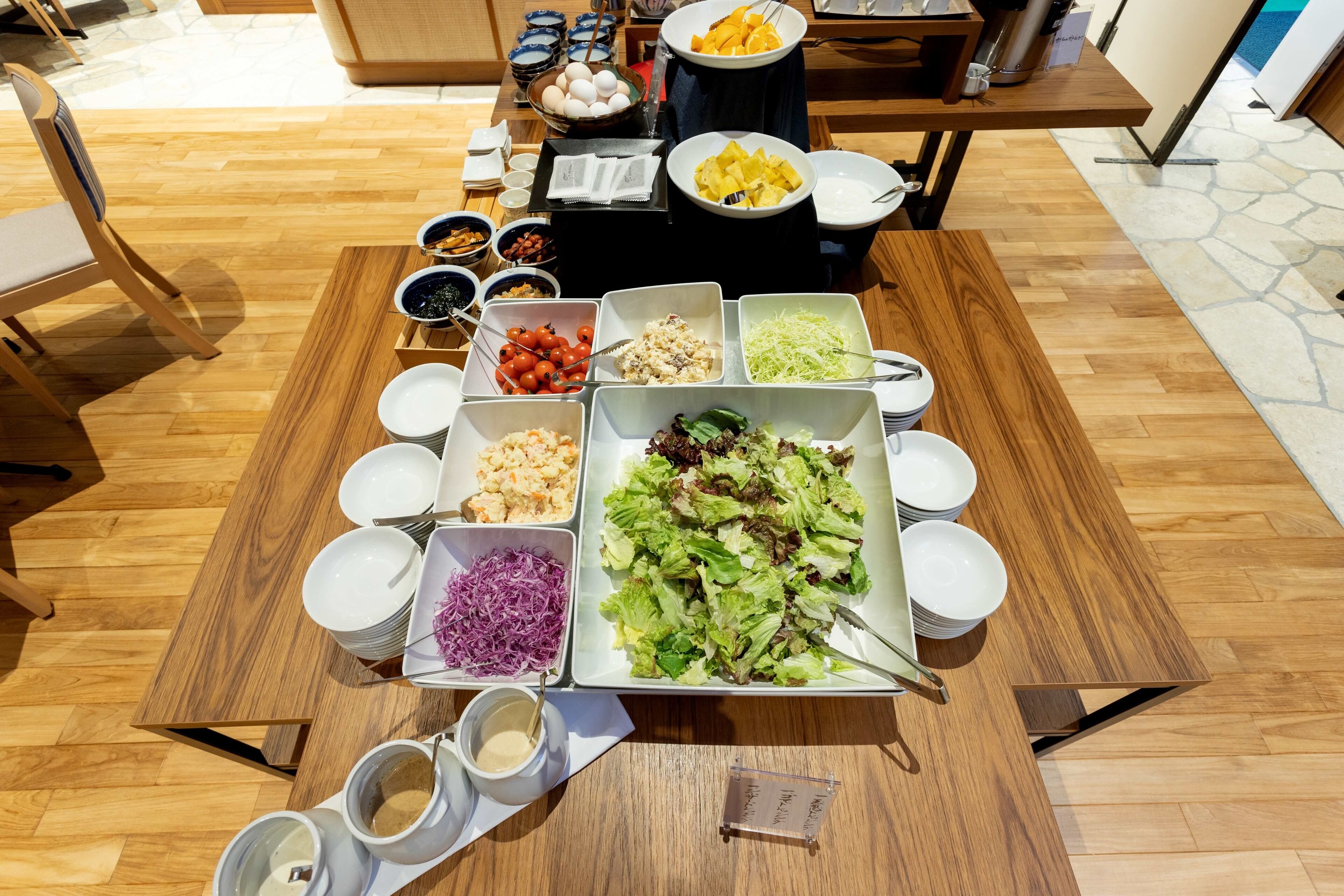 A buffet table with various food items and utensils.