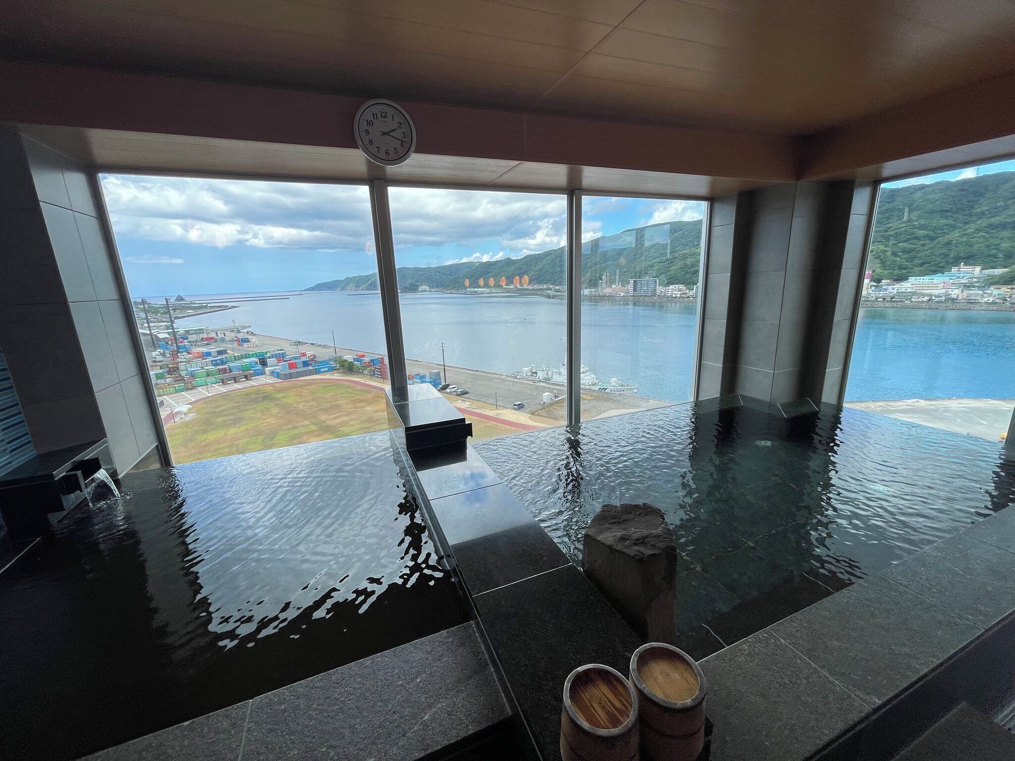 Piscina interior moderna con vistas al puerto y montañas.