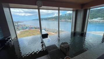 Piscina interior moderna con vistas al puerto y montañas.