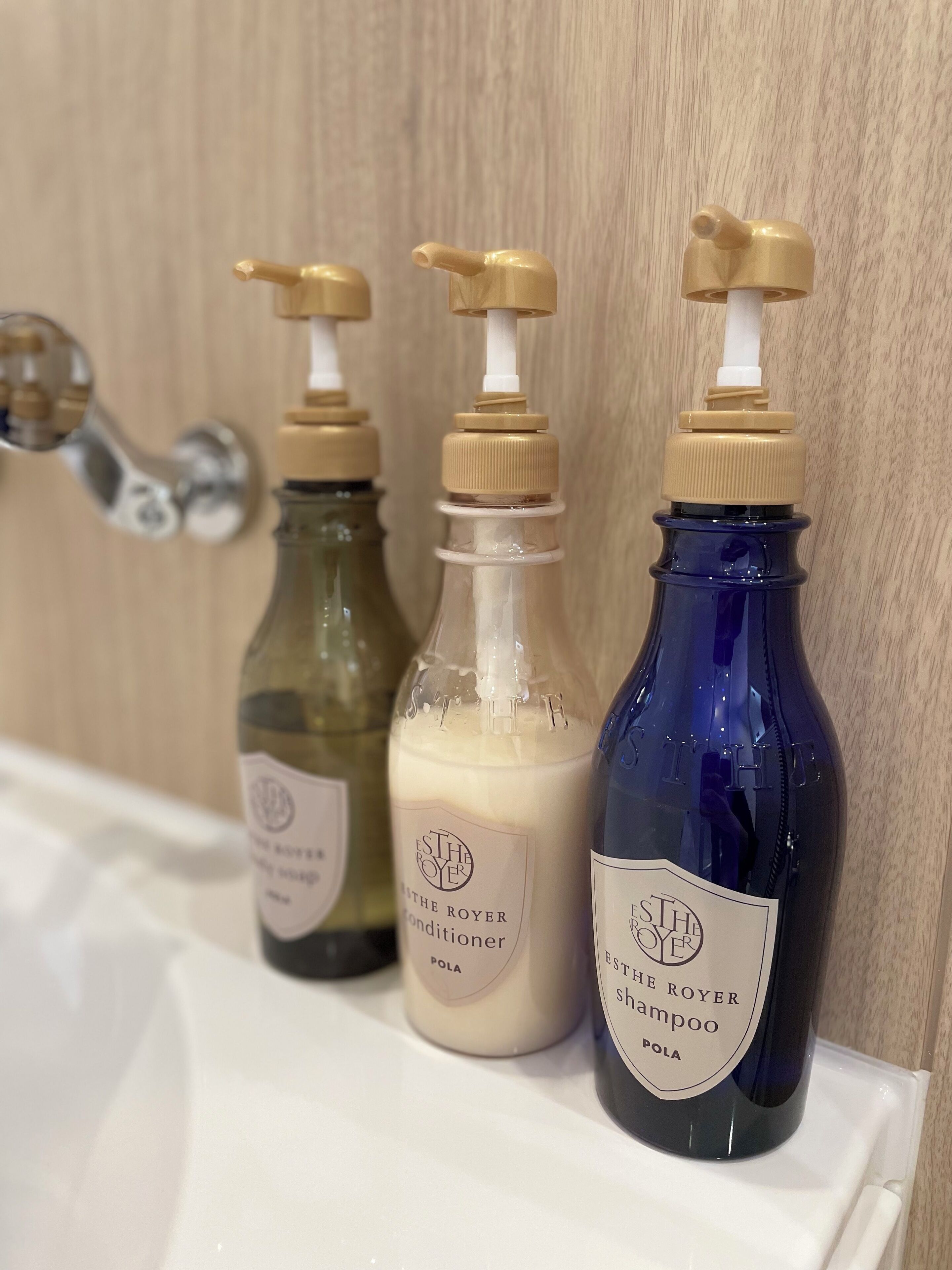 Three bottles of ESTHE ROYER products on a bathroom shelf.