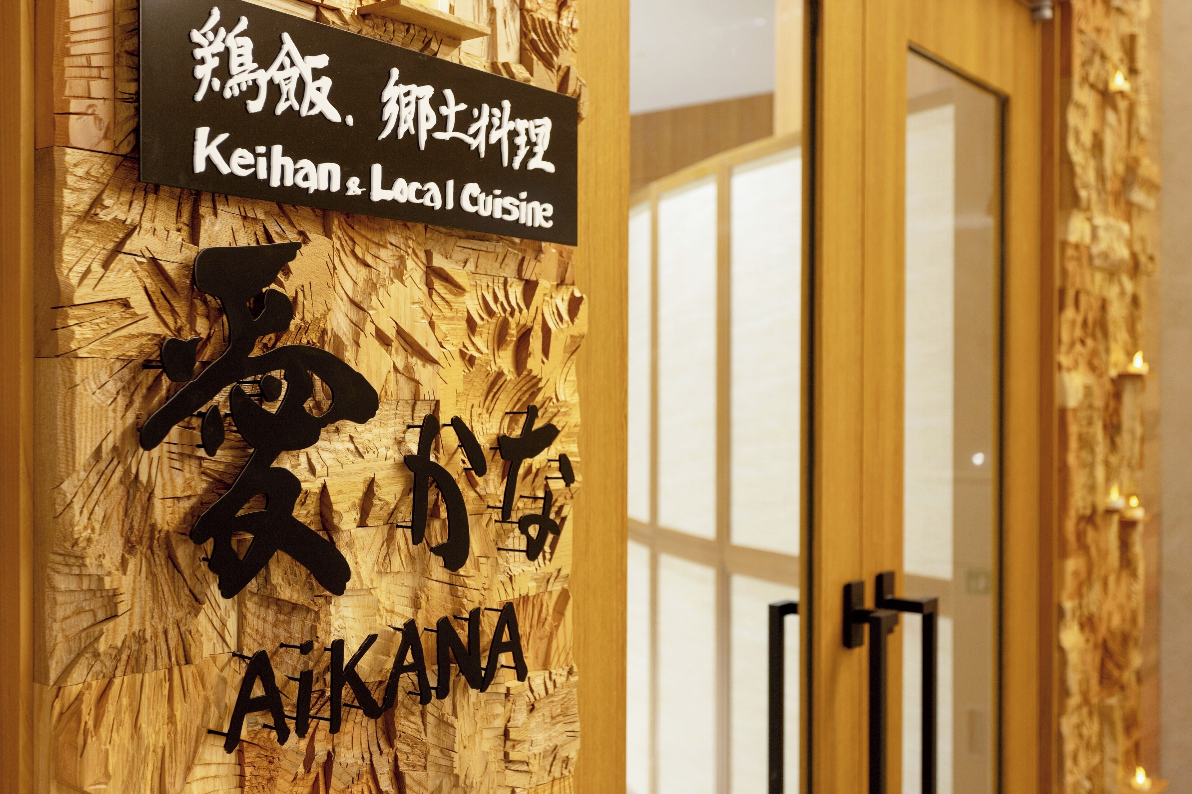 A sign with Chinese characters and English text reading "Keihan Local Cuisine" and "AiKANA".