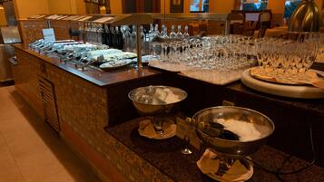 Una mesa de buffet con diversos platos y una gran cantidad de copas de vino.