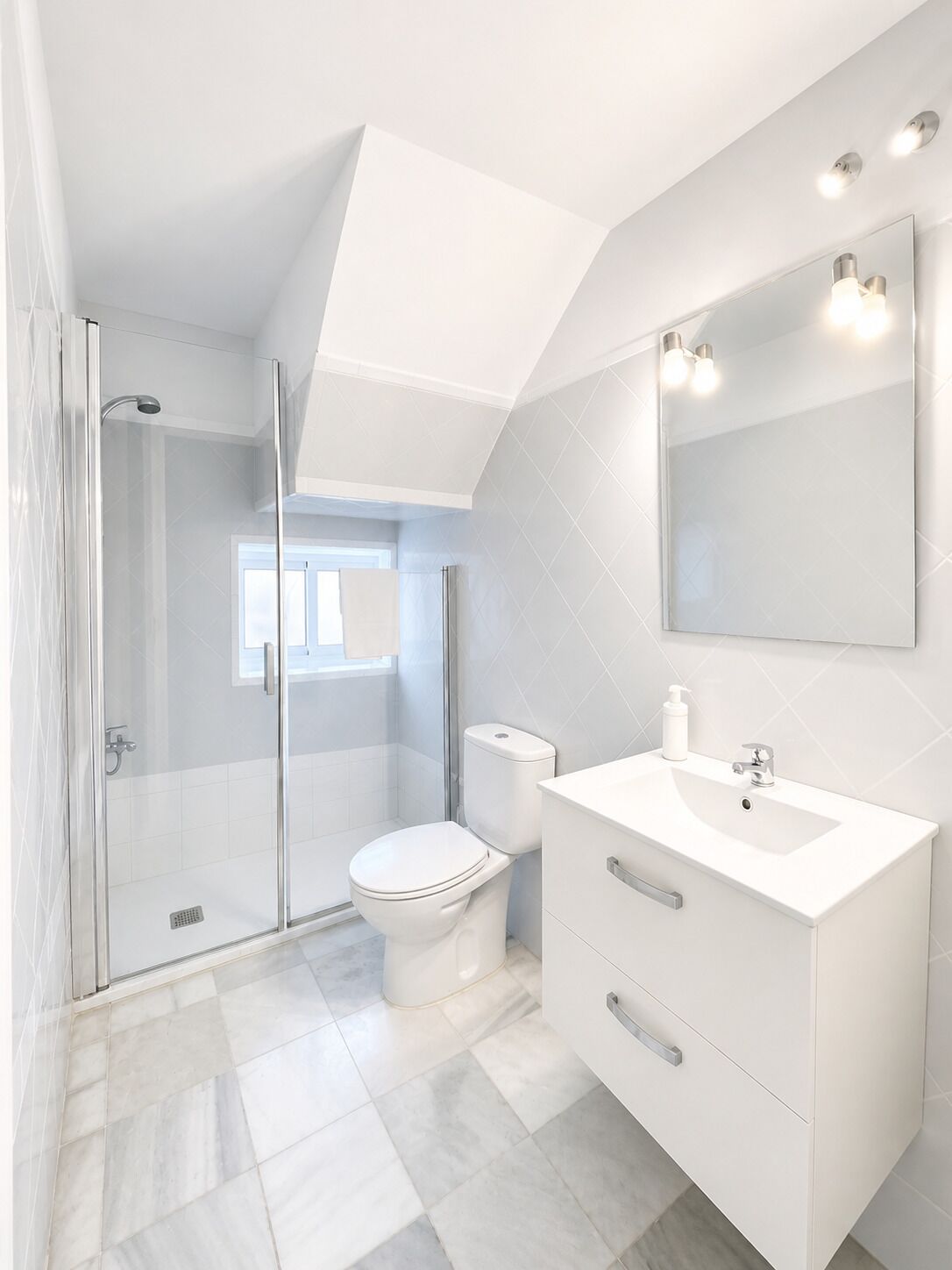 A modern bathroom with a glass shower enclosure, a white toilet, a vanity with a sink, and a large mirror.