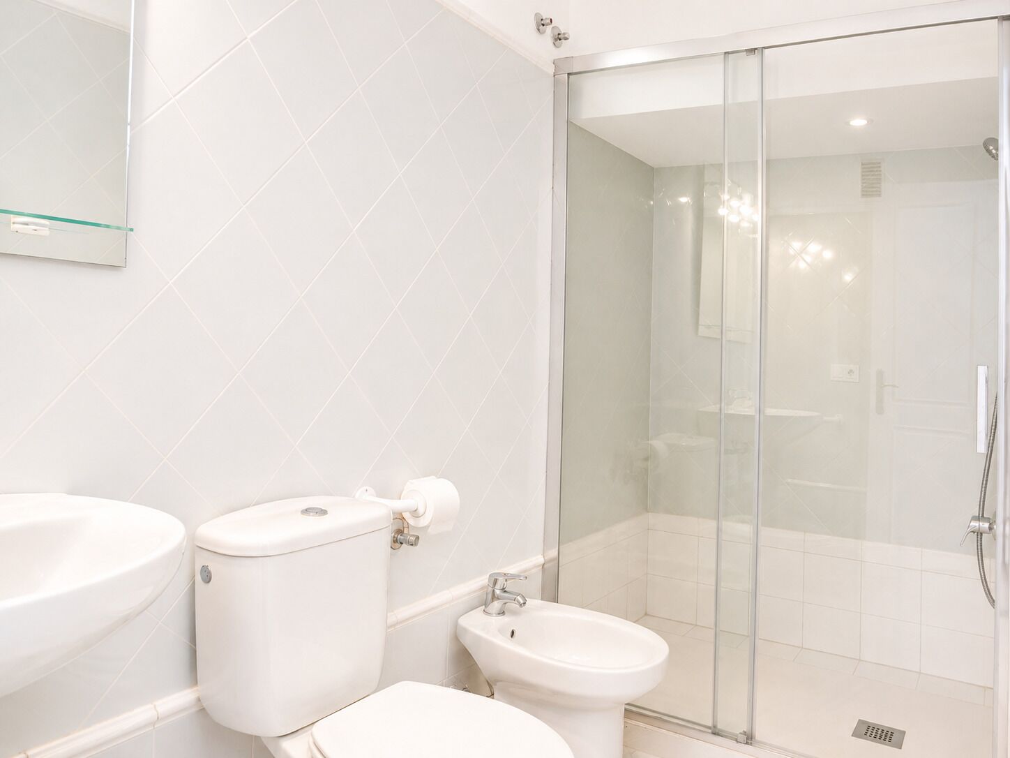 Ein Badezimmer mit Toilette, Bidet und Duschkabine.