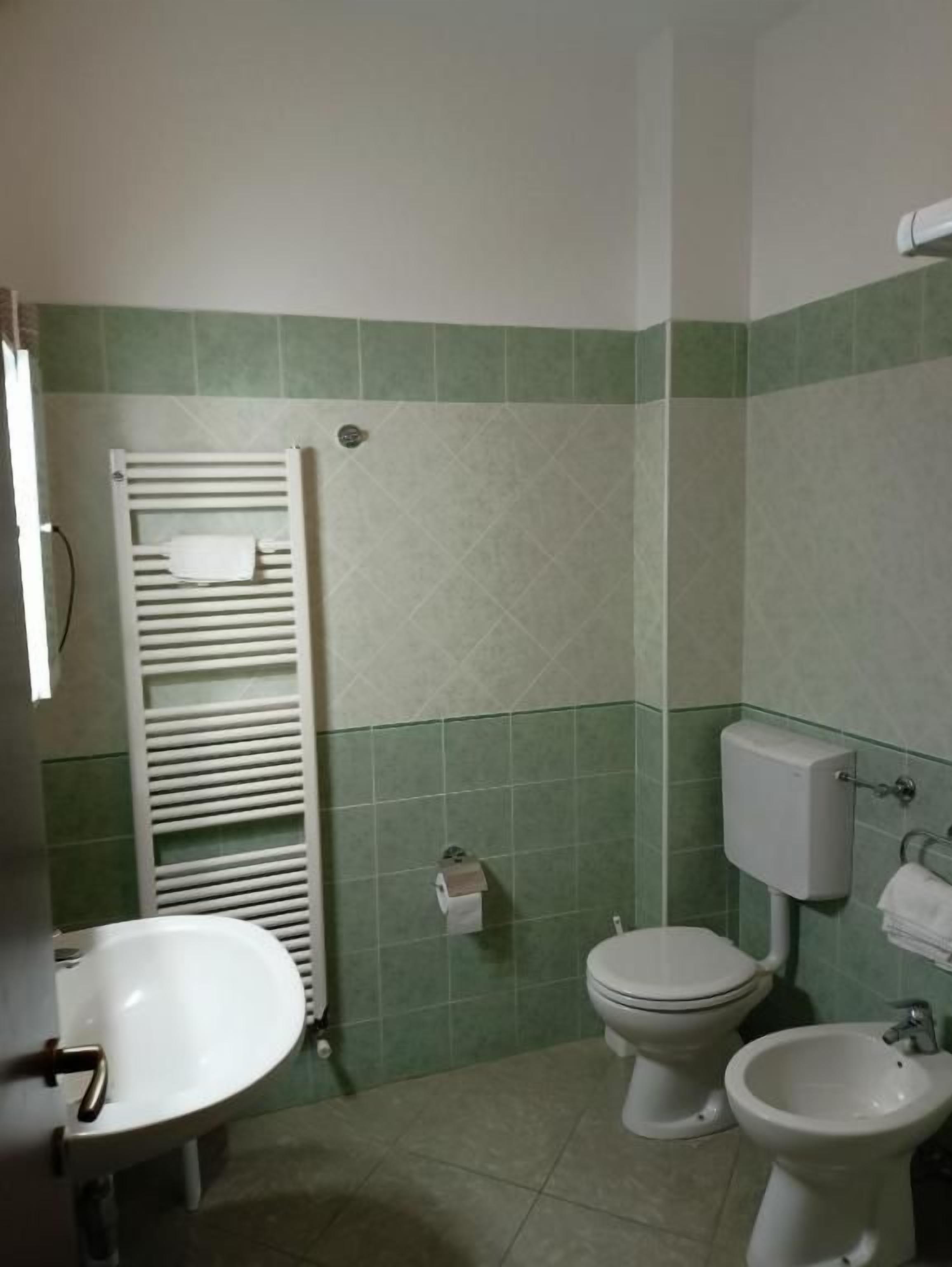 Un baño con inodoro, bidé y lavabo.