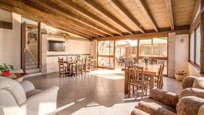 A spacious living area with a wooden ceiling, a fireplace, a dining table, and a sofa. - Hotel Roma Tiburtina (Rome)