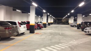 Un estacionamiento de varios niveles con varios coches estacionados en espacios designados.