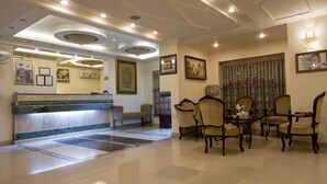 Un espace d’accueil doté d’un comptoir en marbre, d’un banc et d’un coin repas avec des chaises décorées.