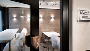 A modern room with a wooden wall, a white table, and a sign indicating it's a V-Room.