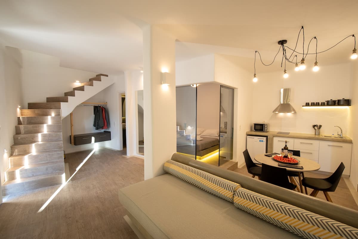 Eine moderne Küche mit Essbereich, einer eingebauten Bank und einer Treppe, die in einen anderen Raum führt.
