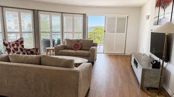 Una sala de estar moderna con sofá, sillón y mueble para televisión.