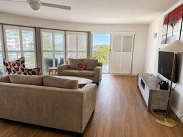 Una sala de estar moderna con sofá, sillón y mueble para televisión.