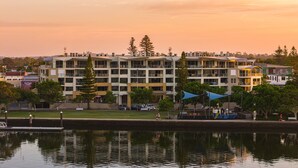 A multi-story building with balconies, a dock, and a reflection in the water. - Riverside Apartments & Hotel Ballina (Ballina)