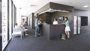 A reception area with a counter, seating, and a TV screen. - Western Sydney University Village- Parramatta Campus (Parramatta)