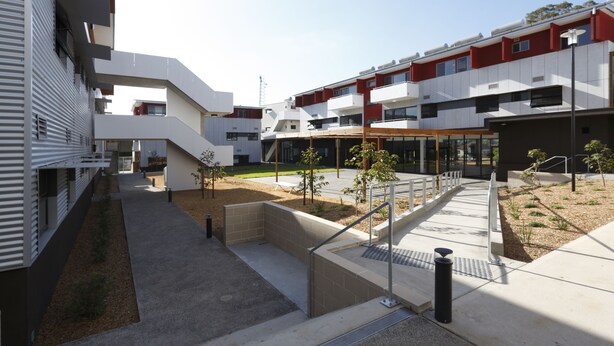 A modern building with a courtyard, outdoor seating, and a covered area. - Western Sydney University Village- Parramatta Campus (Parramatta)