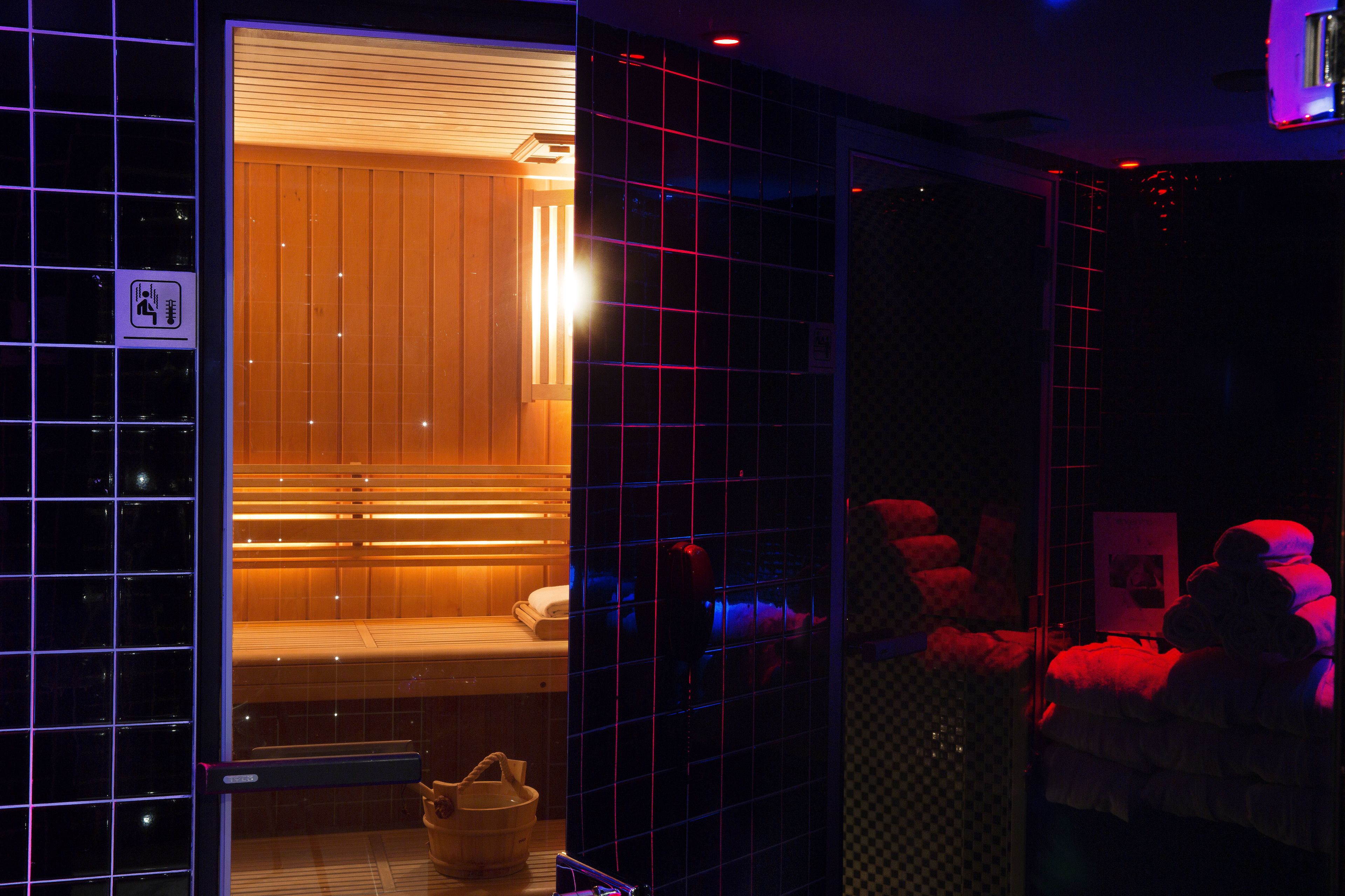 Una sauna con bancos de madera y un banco con toalla.