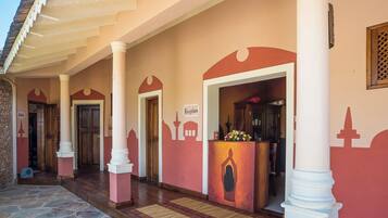 A reception area with a stone floor, a reception desk, and a sign indicating the reception.