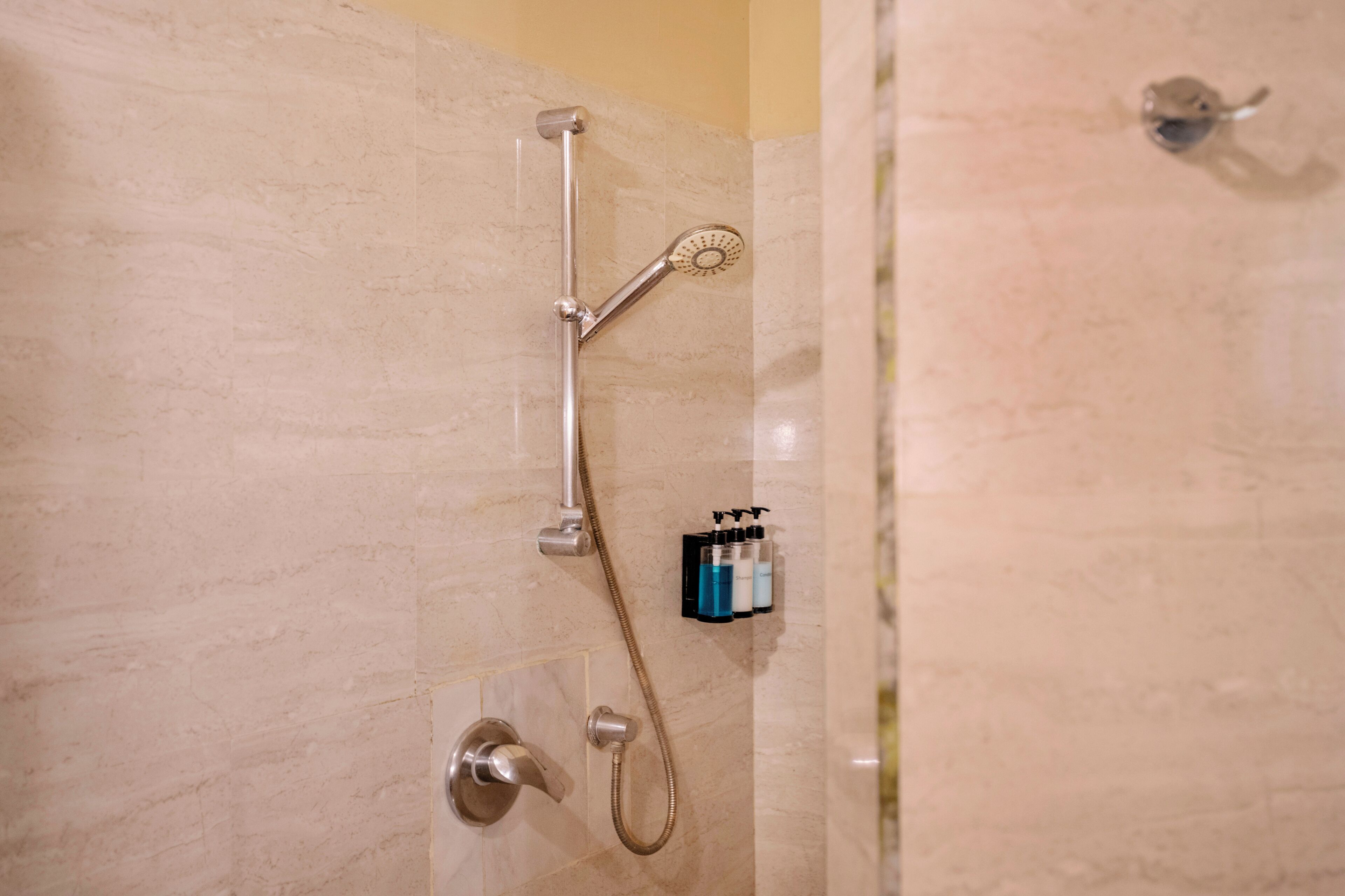 Eine Dusche mit Duschkopf und Wandarmatur.