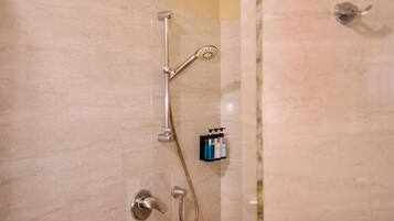 Eine Dusche mit Duschkopf und Wandarmatur.