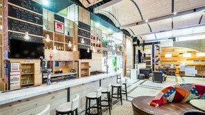 A modern bar area with wooden shelves, bar stools, and a counter. - TRYP by Wyndham New York City Times Square / Midtown (New York)