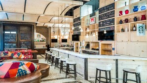 A cozy bar area with a wooden ceiling, a counter with stools, and shelves with various items. - TRYP by Wyndham New York City Times Square / Midtown (New York)