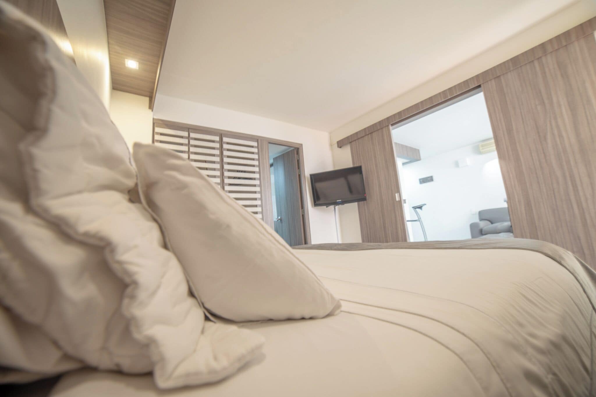 Une chambre d’hôtel avec un lit, un téléviseur fixé au mur et une vue sur l’extérieur.