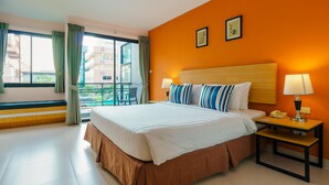 A hotel room with a large bed, two bedside lamps, a nightstand, and a view of the outside balcony.