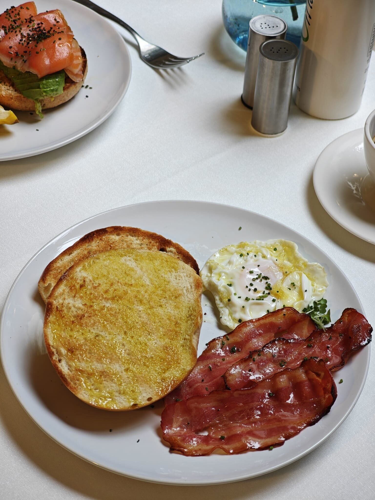 Une assiette de petit-déjeuner avec des toasts, des œufs et du bacon.