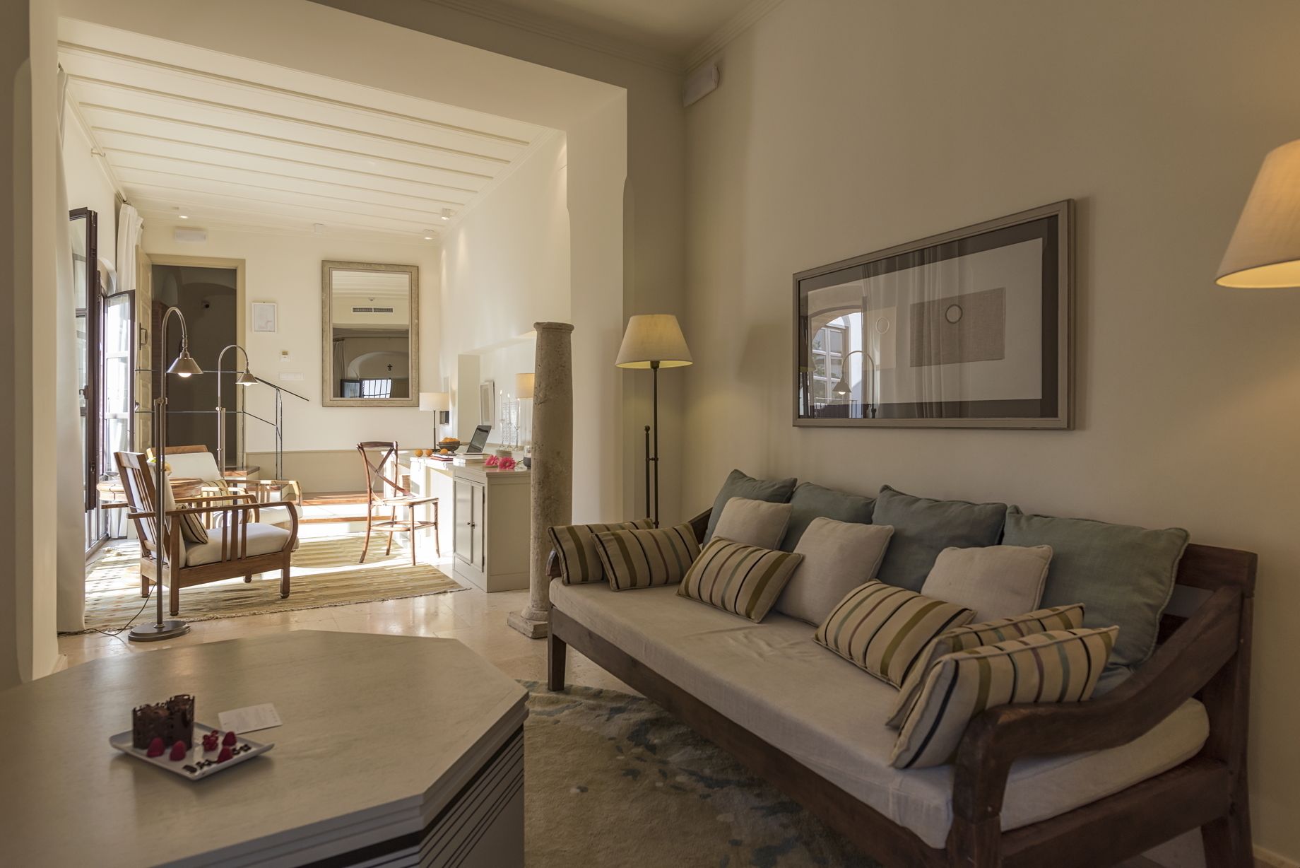 Amplia sala de estar con sofá, mesa de centro y comedor con sillas y una mesa.