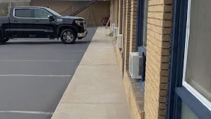 A building with a covered walkway, air conditioning units, and a parked truck. -  Inn On Pim (Sault Ste. Marie)