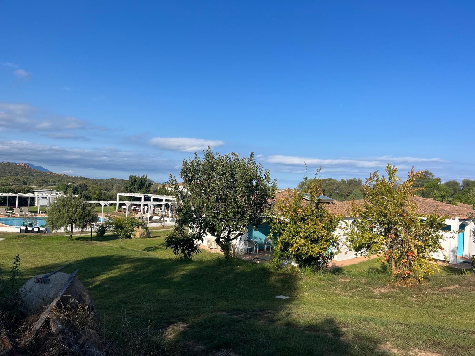 A resort with a pool, outdoor seating, and a view of the surrounding landscape.