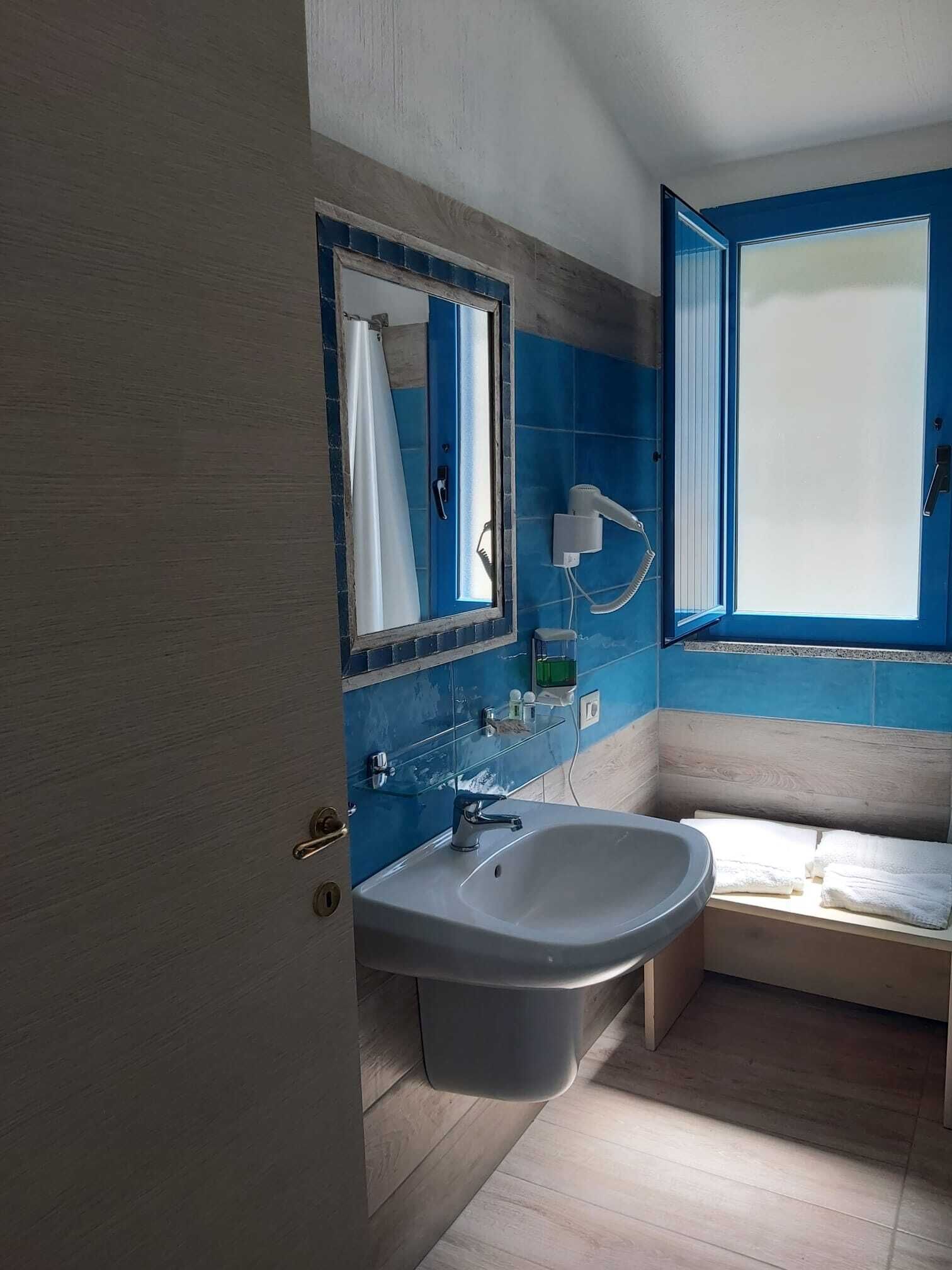 A bathroom with a sink, mirror, and shower.