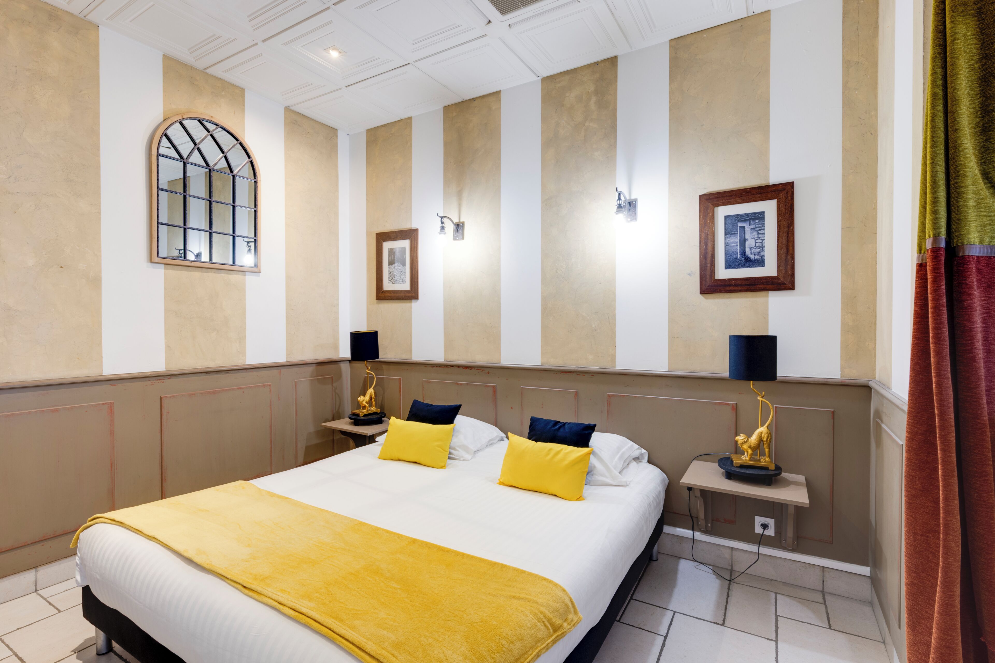 Habitación de hotel con una cama grande, dos mesitas de noche, una ventana y un cuadro colgado en la pared.