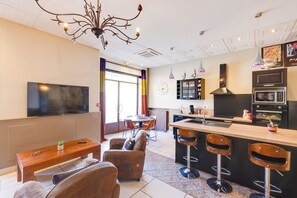 Deluxe appartement | Woonruimte | Een 87-cm flatscreentelevisie met satellietzenders, televisie en Netflix
