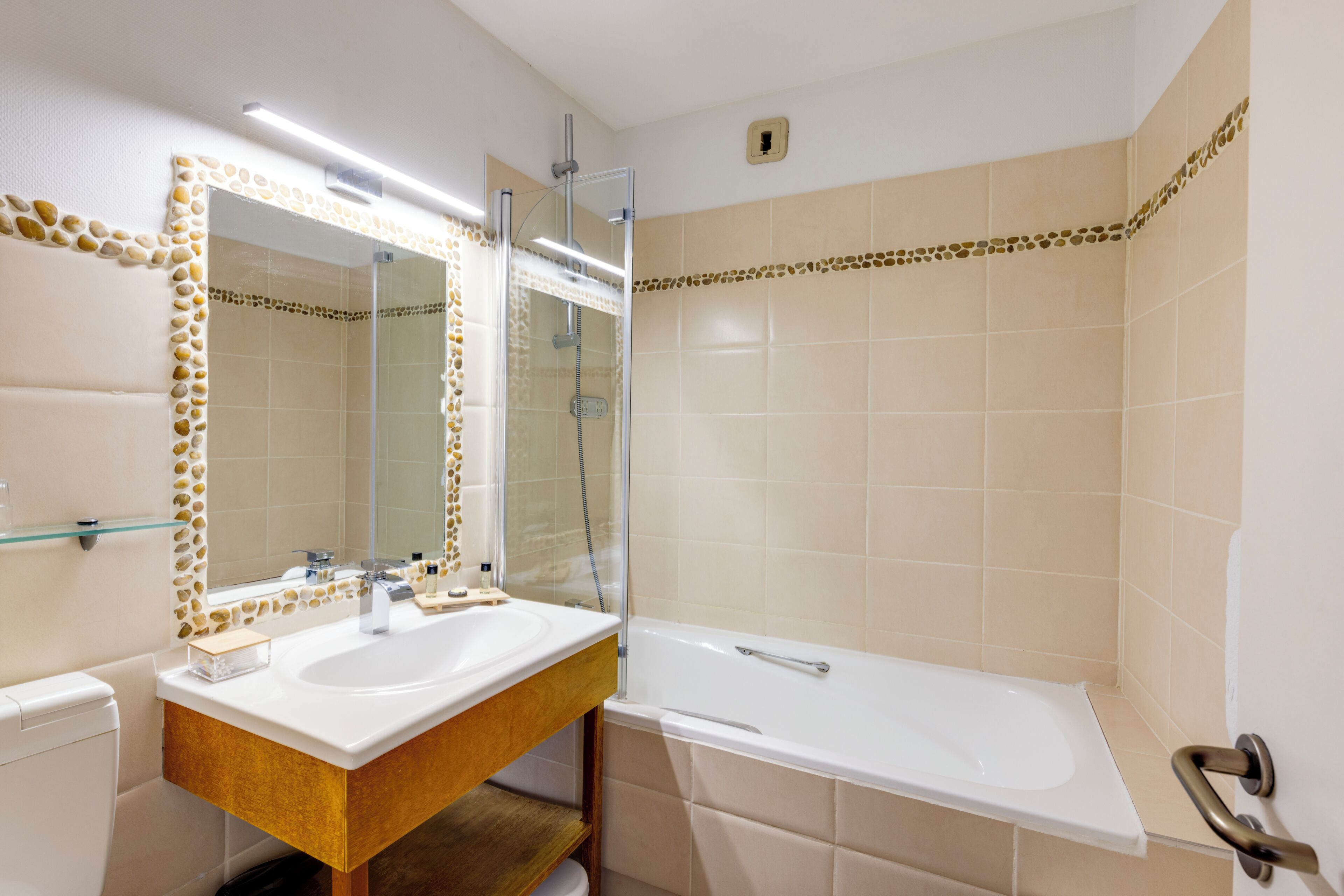 A bathroom with a double sink, a mirror, a bathtub, and a shower.