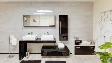 Un baño moderno con dos lavamanos, un espejo grande y una zona de ducha.