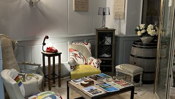A cozy living room with a coffee table, armchairs, a sofa, and a glass cabinet.
