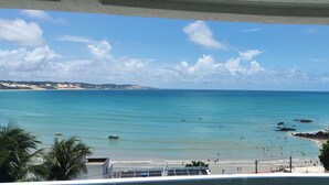 A coastal view with a beach, clear sky, and distant hills. - Aparthotel Margherita (Natal)