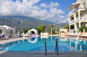 A swimming pool with lounge chairs and a white gazebo, surrounded by mountains and a clear sky. - Lukka Exclusive Hotel - Adult Only +12 (Kas)