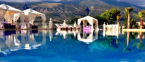 Una piscina al aire libre de temporada, sombrillas